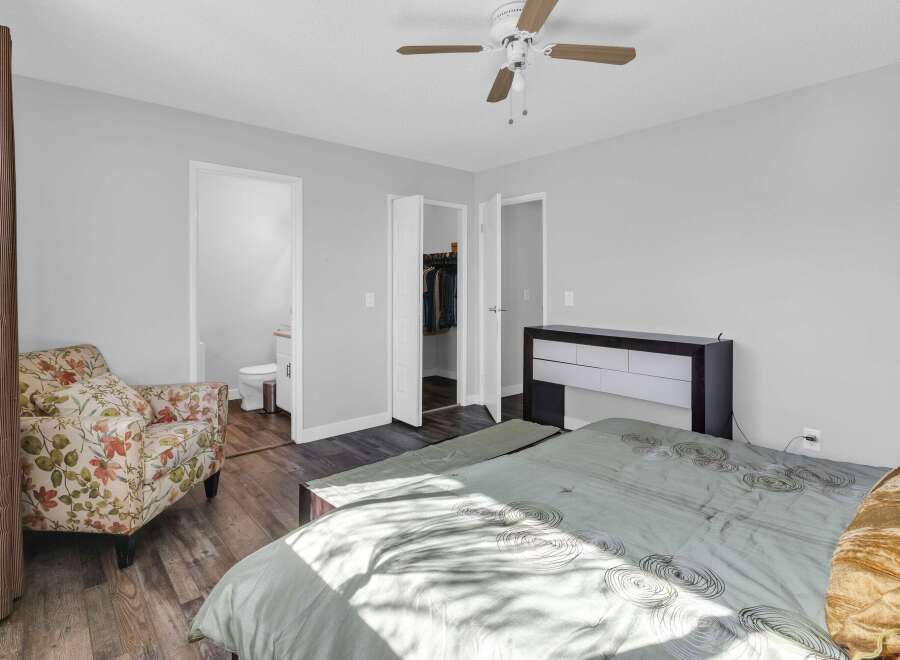 Step into this inviting bedroom, featuring a comfortable bed and a stylish armchair.