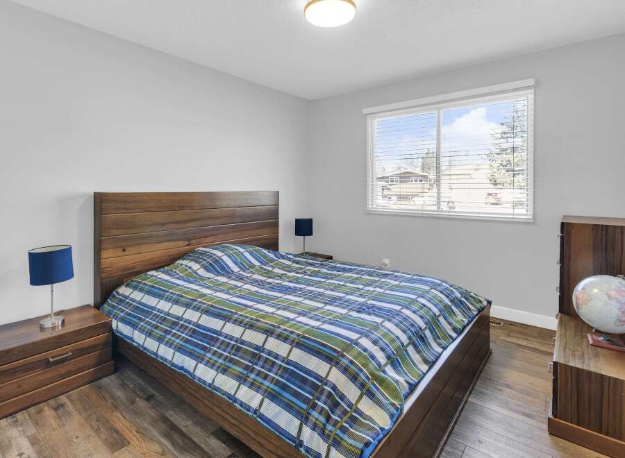 This inviting bedroom features a stylish wooden bed frame and matching nightstands, creating a cohesive and warm atmosphere.