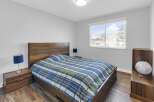 This inviting bedroom features a stylish wooden bed frame and matching nightstands, creating a cohesive and warm atmosphere.