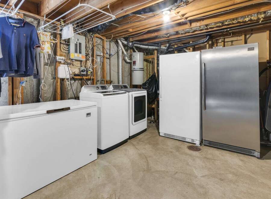 Discover the convenience of this property's well-equipped laundry area, featuring a washer, dryer, and additional freezer space.