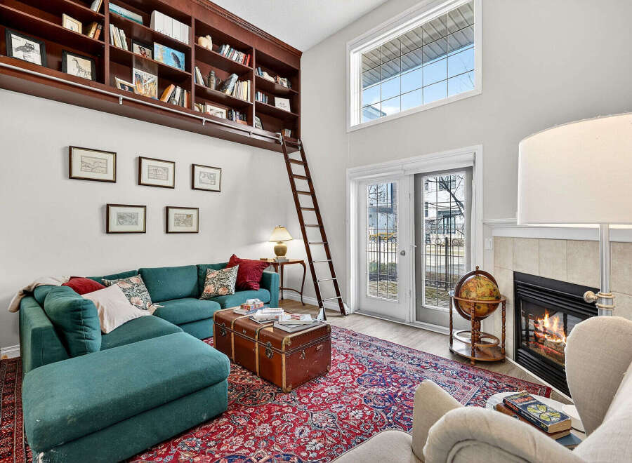 Step into luxury with this stunning property featuring a cozy fireplace and a unique built-in bookshelf.