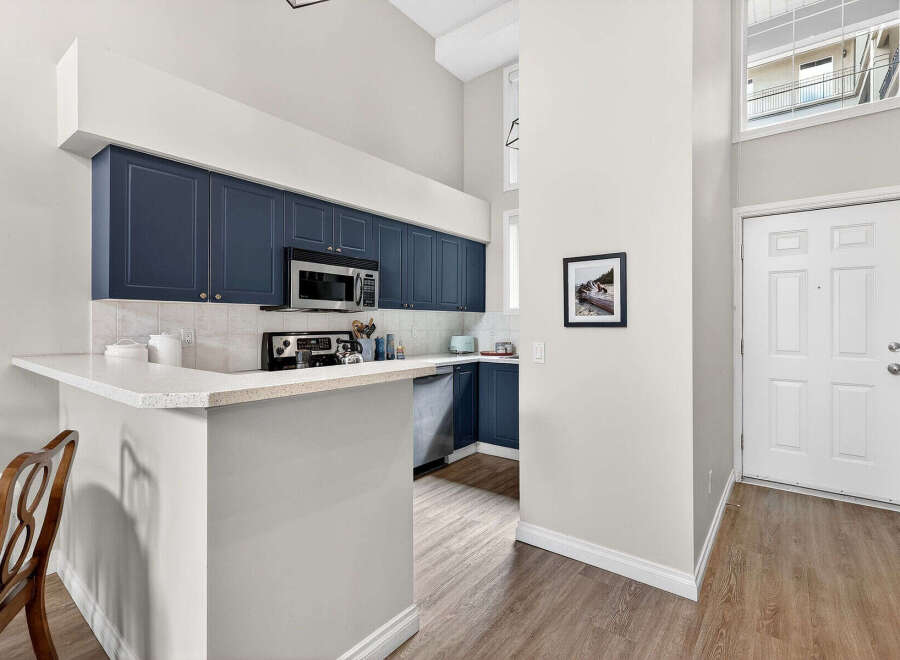 This stunning kitchen boasts modern navy cabinets, a sleek countertop, and stainless steel appliances, creating a stylish and functional space.