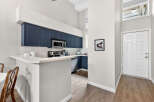 This stunning kitchen boasts modern navy cabinets, a sleek countertop, and stainless steel appliances, creating a stylish and functional space.