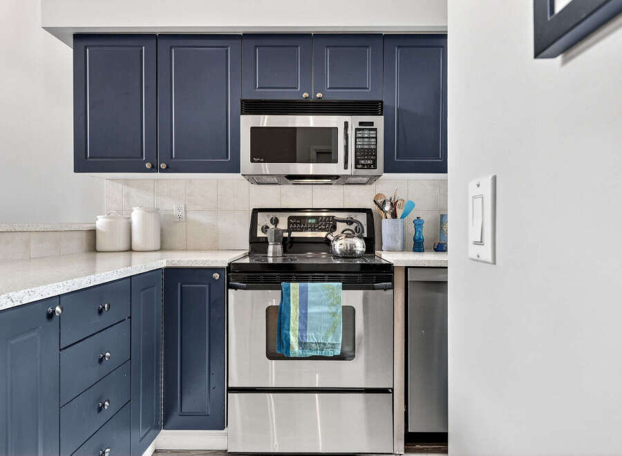 This kitchen boasts modern navy blue cabinetry, offering ample storage and a stylish aesthetic.