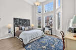 This stunning bedroom boasts a unique design with soaring ceilings and an abundance of natural light streaming through the large windows.