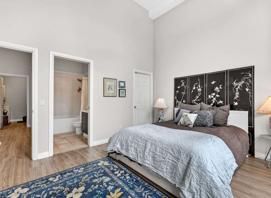 This stunning bedroom boasts a serene ambiance with its high ceilings and elegant decor.