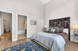 This stunning bedroom boasts a serene ambiance with its high ceilings and elegant decor.