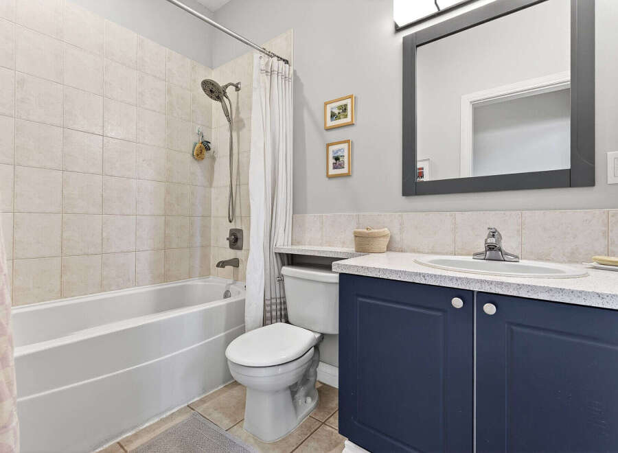 Step into this beautifully designed bathroom, featuring a modern vanity with ample storage.