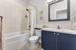 Step into this beautifully designed bathroom, featuring a modern vanity with ample storage.