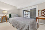 This cozy bedroom features a comfortable bed with a stylish patterned duvet and a plush green headboard.