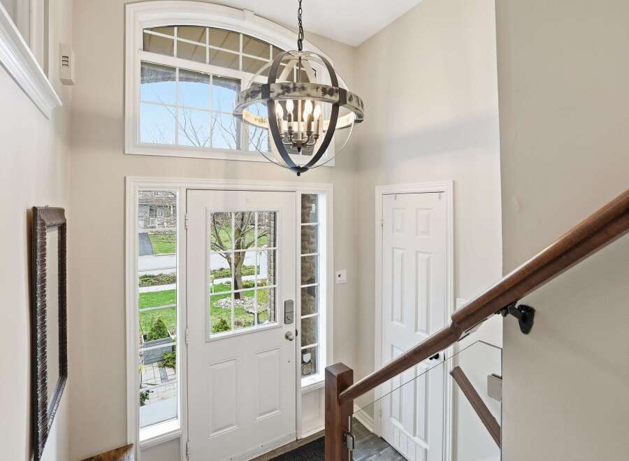 Step into this inviting entryway, showcasing a stunning chandelier and a grand staircase.