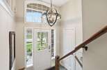 Step into this inviting entryway, showcasing a stunning chandelier and a grand staircase.