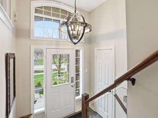 Step into this inviting entryway, showcasing a stunning chandelier and a grand staircase.