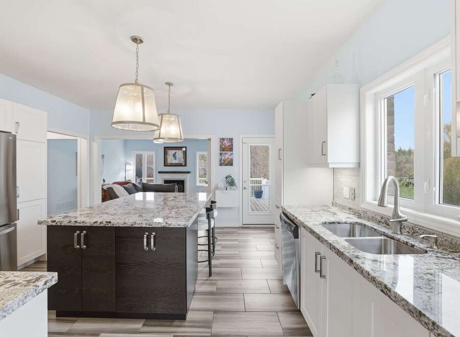 This stunning kitchen boasts a modern design with sleek white cabinetry and a spacious island, perfect for both cooking and entertaining.