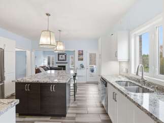 This stunning kitchen boasts a modern design with sleek white cabinetry and a spacious island, perfect for both cooking and entertaining.