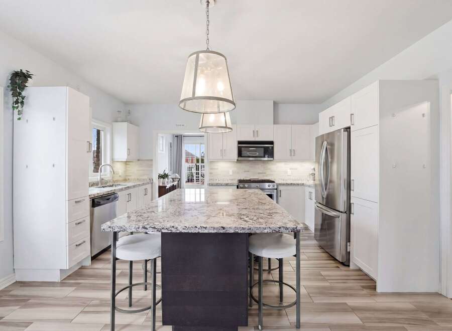 Step into this stunning kitchen, the heart of the home, featuring a large island with a beautiful granite countertop, perfect for meal prep and entertaining.