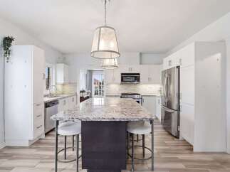 Step into this stunning kitchen, the heart of the home, featuring a large island with a beautiful granite countertop, perfect for meal prep and entertaining.