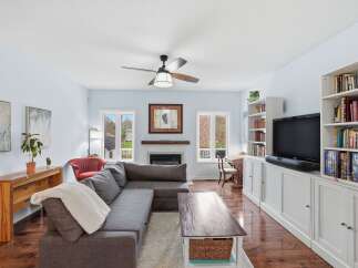 This stunning living room boasts a cozy fireplace, perfect for chilly evenings, and a sleek entertainment center.
