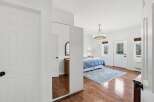 Step into this bright and airy bedroom, featuring beautiful hardwood floors and a stylish chandelier.