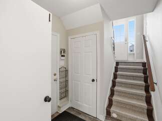 Step into this inviting entryway, featuring a staircase leading to the upper levels.