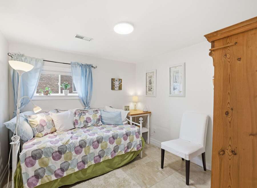 This charming bedroom offers a cozy retreat with its inviting daybed and soft, patterned bedding.