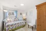 This charming bedroom offers a cozy retreat with its inviting daybed and soft, patterned bedding.