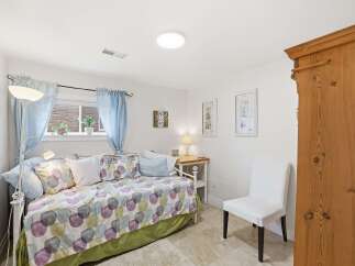 This charming bedroom offers a cozy retreat with its inviting daybed and soft, patterned bedding.