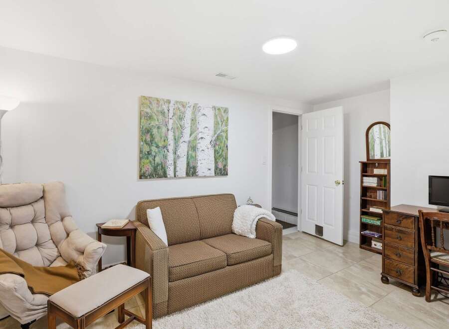 This inviting living space features a cozy sofa, a comfortable armchair, and a stylish artwork, creating a warm and welcoming atmosphere.