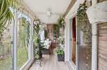 Step into a lush, plant-filled sunroom that brings the outdoors in.