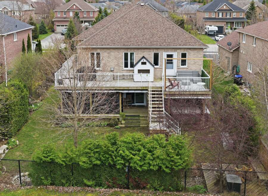 This stunning property boasts a spacious backyard with lush greenery and a charming deck, perfect for outdoor entertaining.