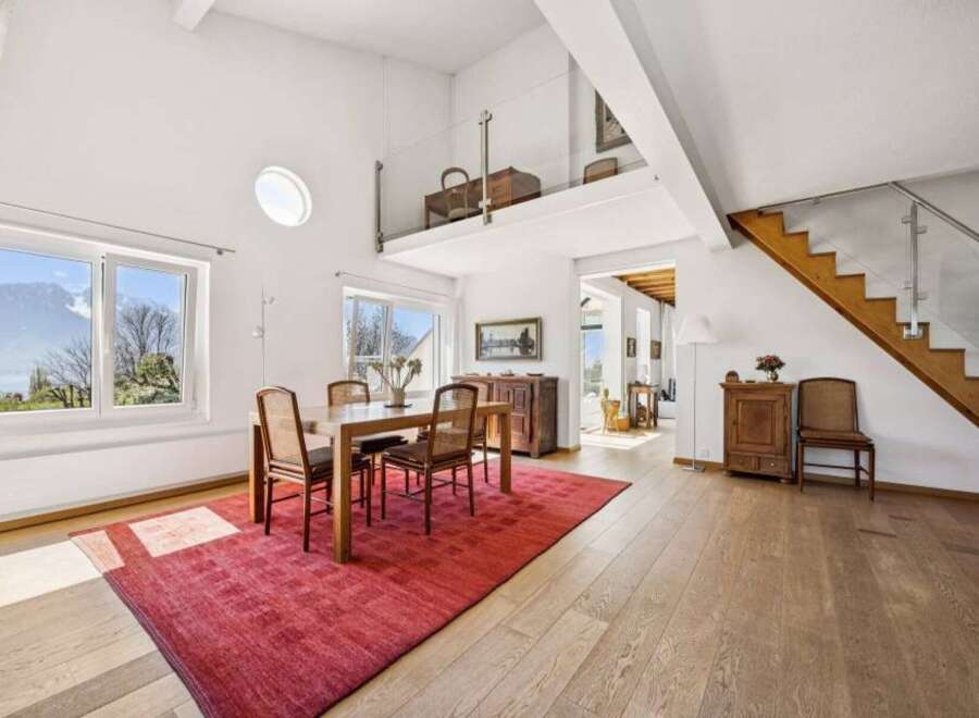 Experience breathtaking mountain and lake views from this stunning property, featuring a bright and airy dining area with large windows.