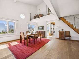 Experience breathtaking mountain and lake views from this stunning property, featuring a bright and airy dining area with large windows.