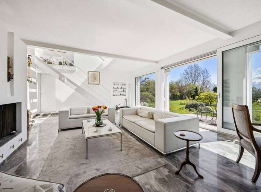 Experience modern living in this spacious living room, featuring sleek white sofas and a minimalist coffee table.