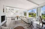 Experience modern living in this spacious living room, featuring sleek white sofas and a minimalist coffee table.