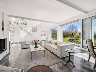 Experience modern living in this spacious living room, featuring sleek white sofas and a minimalist coffee table.