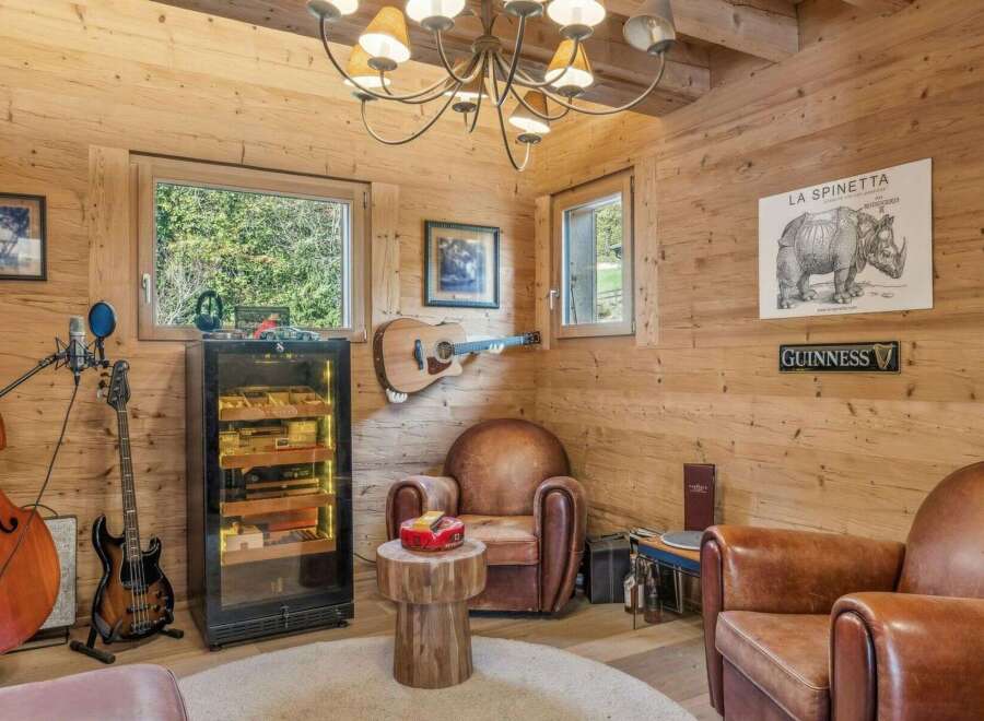 Step into a luxurious retreat with this stunning property, featuring a dedicated cigar room and a cozy seating area.