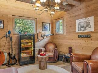 Step into a luxurious retreat with this stunning property, featuring a dedicated cigar room and a cozy seating area.