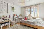 This charming bedroom features a cozy bed, a stylish white piano, and a functional vanity area.