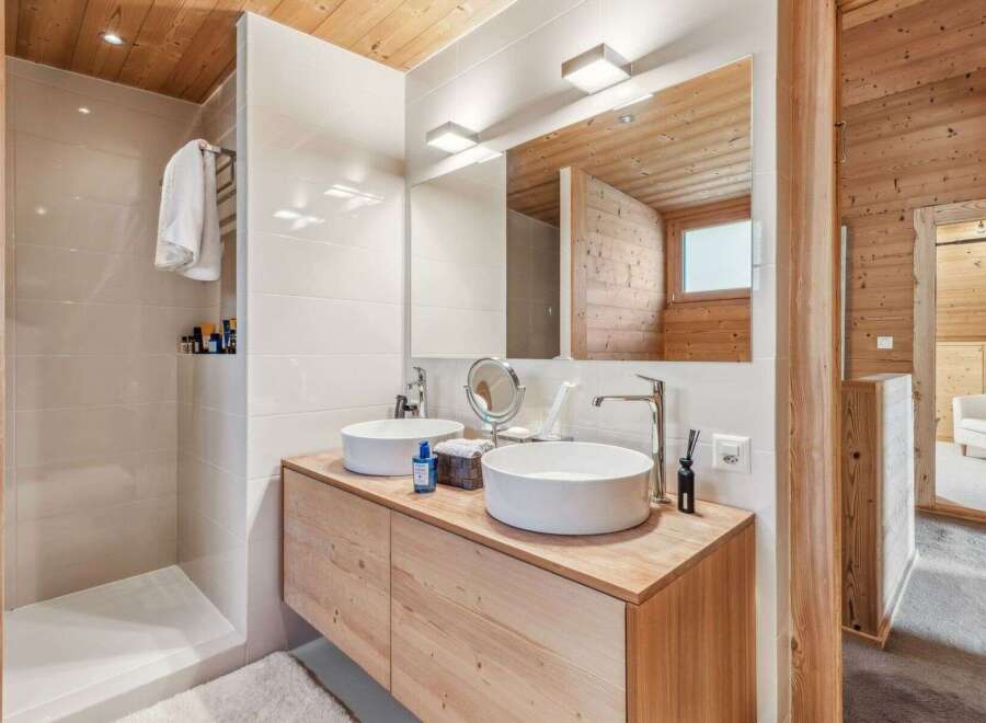 This stunning bathroom boasts a modern design with natural wood accents, creating a warm and inviting atmosphere.