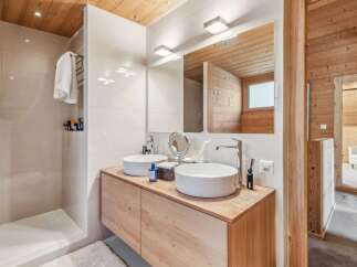 This stunning bathroom boasts a modern design with natural wood accents, creating a warm and inviting atmosphere.