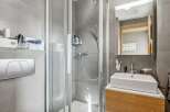 This modern bathroom features a sleek glass shower enclosure, perfect for a refreshing start to your day.