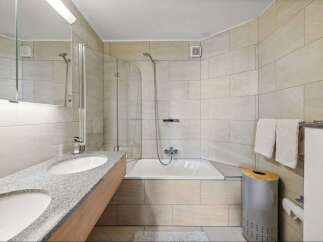 This modern bathroom features a sleek design with a double sink vanity and a luxurious soaking tub.