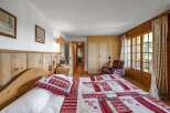 Experience the charm of this cozy bedroom, featuring a rustic wooden bed frame and a beautifully patterned quilt.