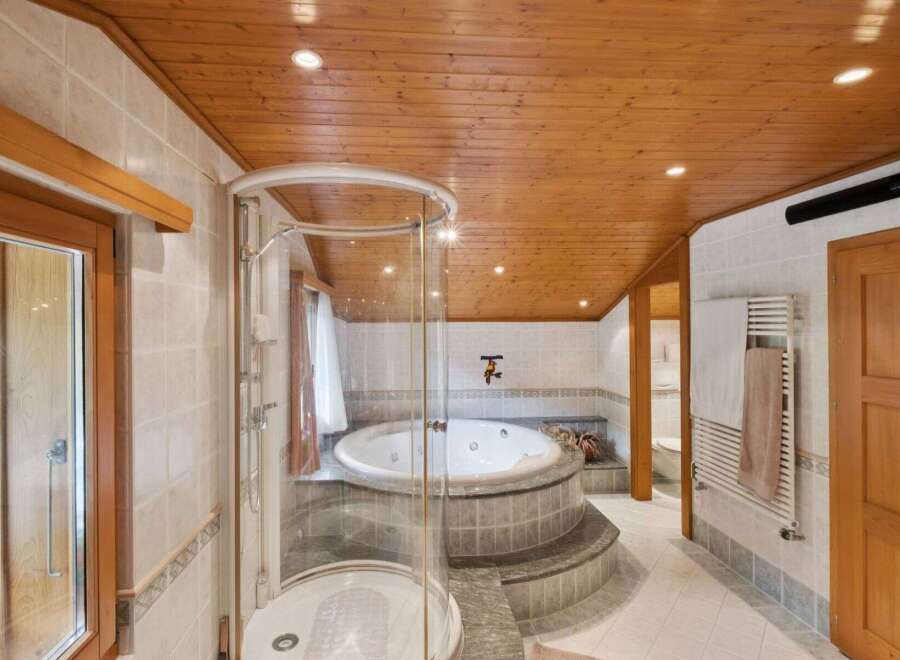Step into luxury with this stunning bathroom featuring a circular jacuzzi and a separate shower.