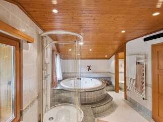 Step into luxury with this stunning bathroom featuring a circular jacuzzi and a separate shower.