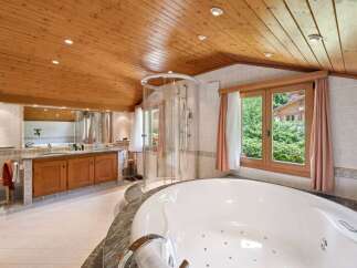 Indulge in luxury within this stunning bathroom, featuring a spacious jacuzzi tub and a separate shower.