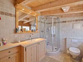 This stunning bathroom features a luxurious design with natural wood elements and a modern shower.