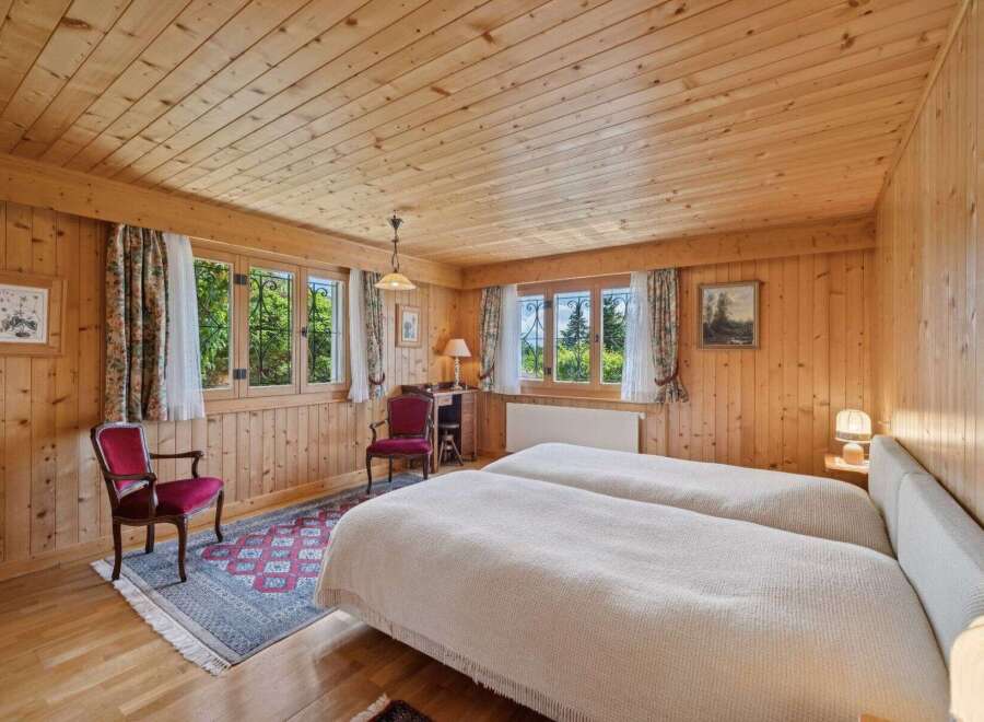 Step into a cozy bedroom retreat featuring warm wooden paneling and a charming ambiance.