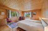 Step into a cozy bedroom retreat featuring warm wooden paneling and a charming ambiance.