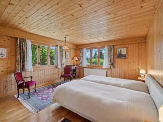 Step into a cozy bedroom retreat featuring warm wooden paneling and a charming ambiance.